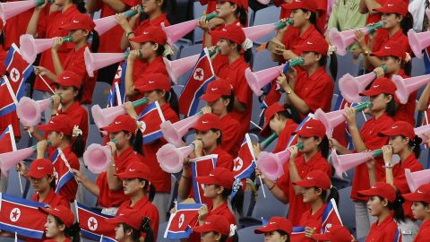 North Korean cheering squad hold their national flag and cheer 04 September 2005.  