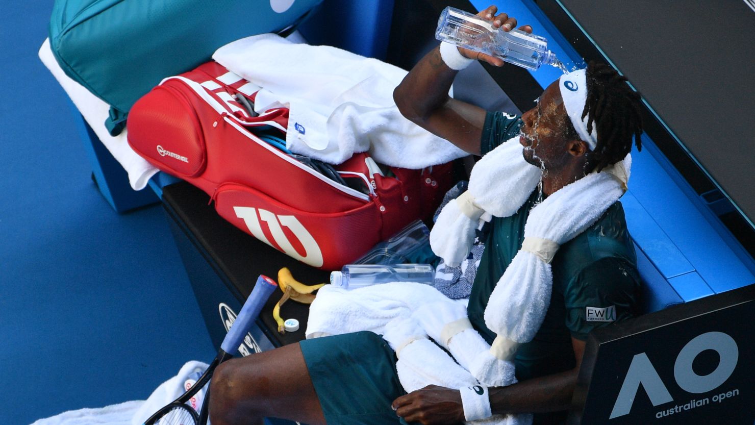 France's Gael Monfils pours water on himself to cool down from the heat during their men's singles second round match against Serbia's Novak Djokovic on day four of the Australian Open tennis tournament in Melbourne on January 18, 2018. / AFP PHOTO / SAEED KHAN / -- IMAGE RESTRICTED TO EDITORIAL USE - STRICTLY NO COMMERCIAL USE --        (Photo credit should read SAEED KHAN/AFP/Getty Images)