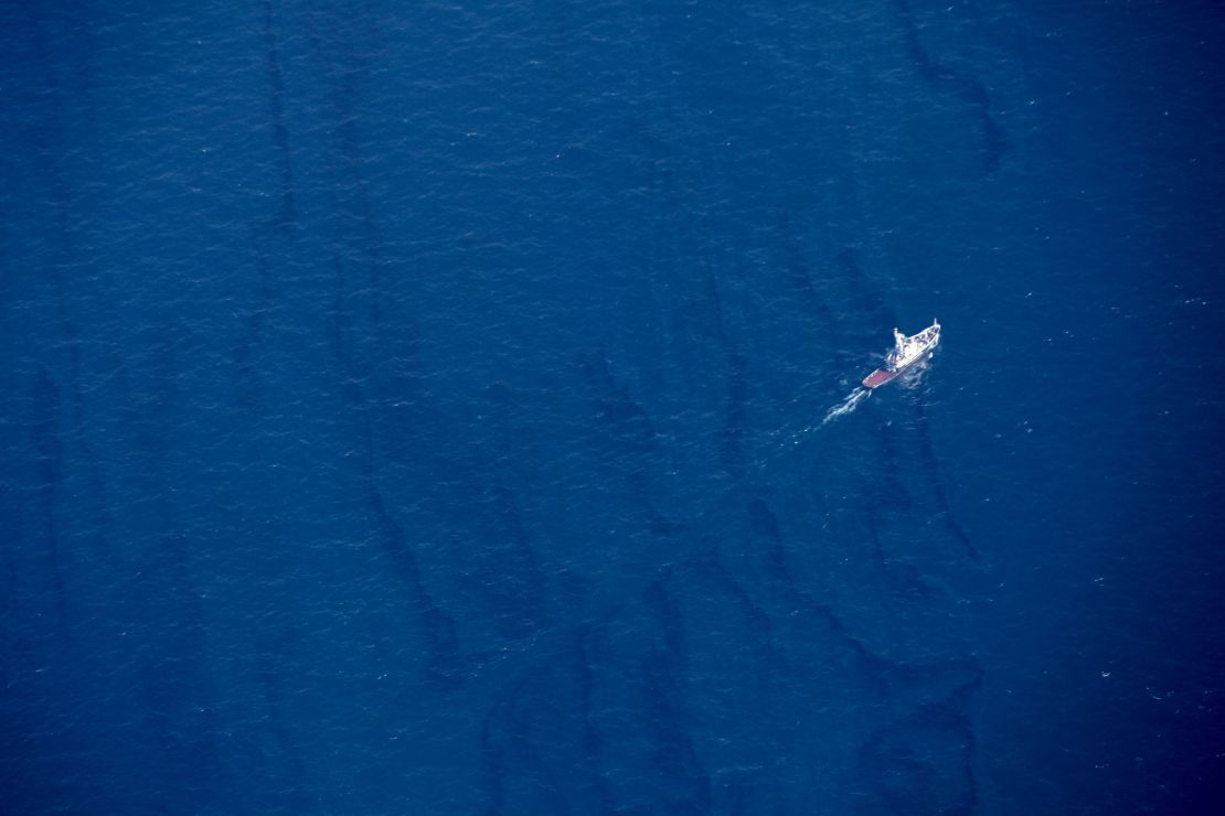 In this Jan. 15, 2018, aerial photo released by China's Xinhua News Agency, a boat moves through an oil slick on the surface of the East China Sea left by oil leaking from the sunken Iranian tanker ship Sanchi. 