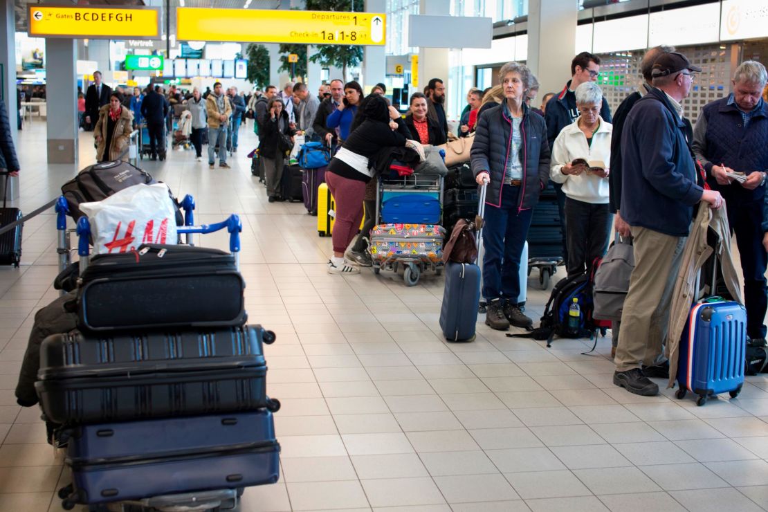 A group of travelers line up at Schiphol Airport near Amsterdam, Thursday.