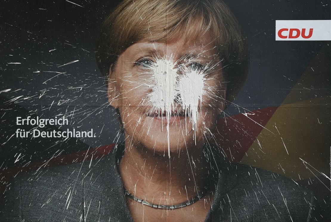 Chancellor Angela Merkel, pictured here on a vandalized campaign billboard, has struggled to build a new government since elections in September.
