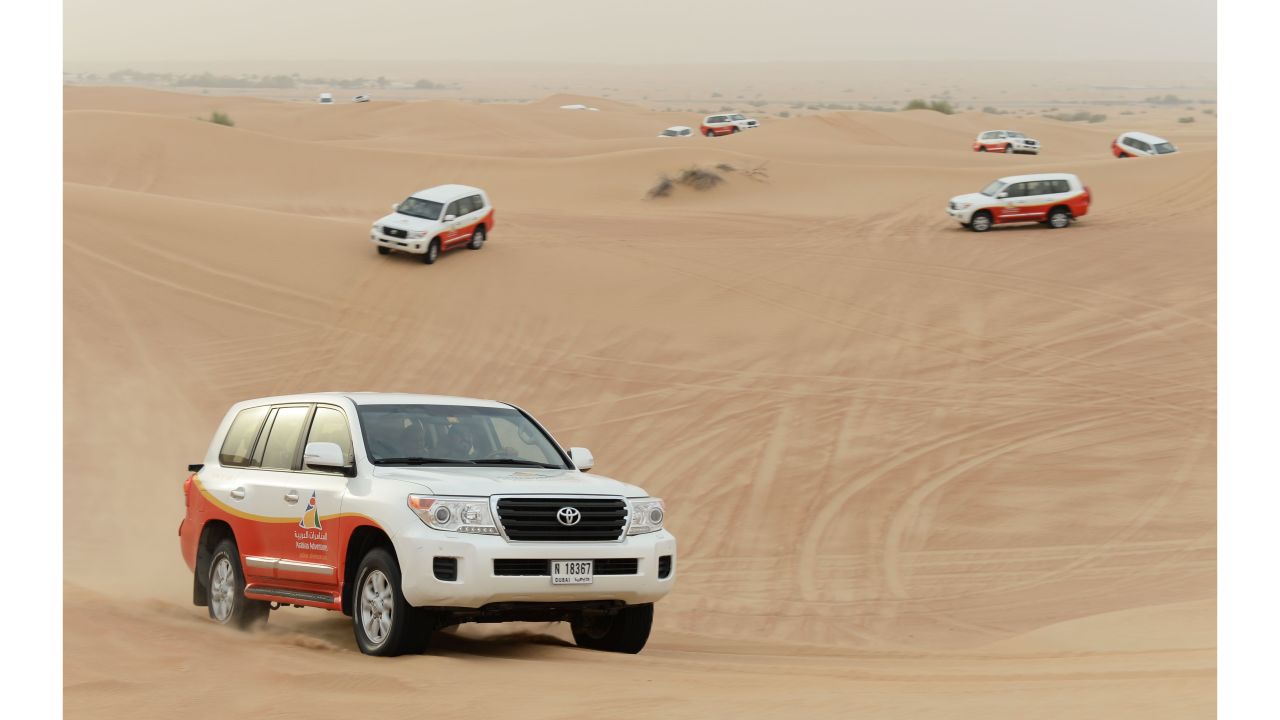 Jeeps traverse the sand dunes outside Dubai. If you don't head out into the desert, you miss the full experience.