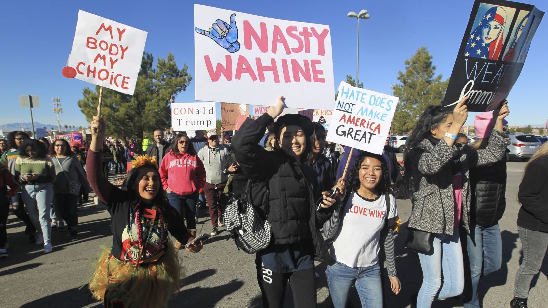 Protesters carry signs as they make their way to Sam Boyd Stadium for the Women's March rally on January 21, in Las Vegas, Nevada.