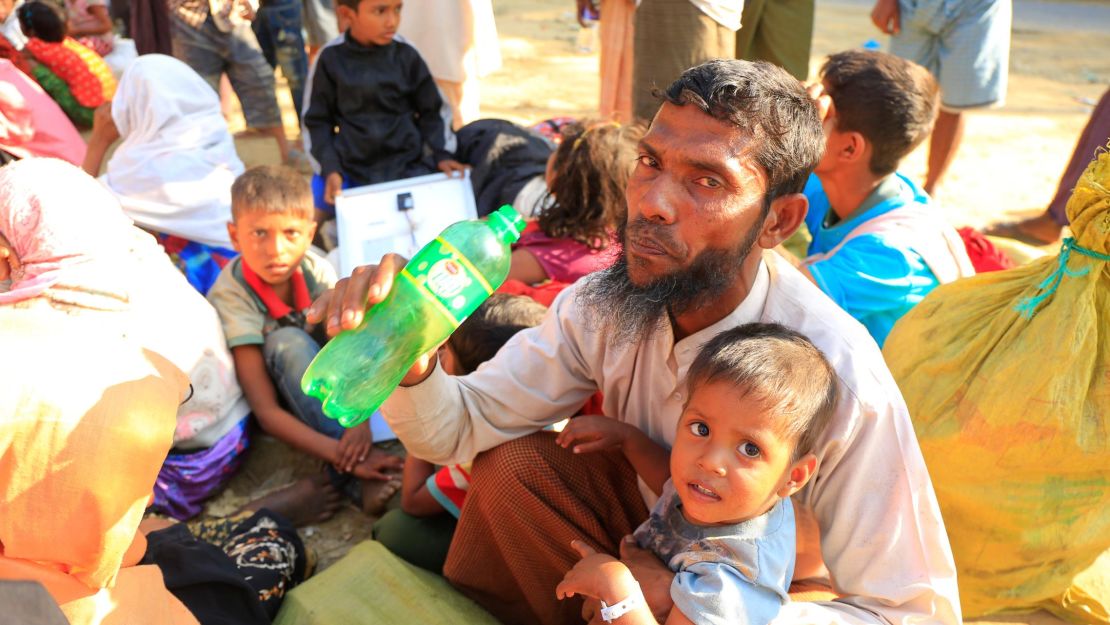 Mohammed Salim drinks water while sitting at the road side near Bhalukhali camp, Cox's Bazar. Even the final steps of his journey were an arduous process. At the border, he says a Bangladeshi money changer ran off with his money.  