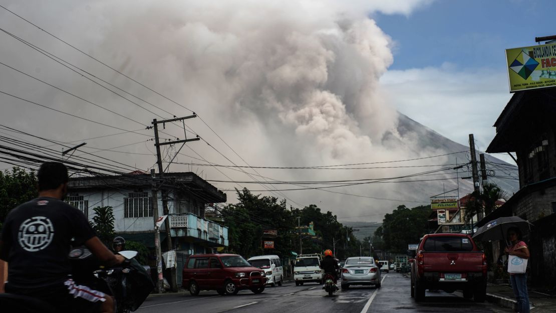 Motorists travel on a highway as Mount Mayon shot up a giant mushroom-shaped cloud as it continues to erupt near Camalig town, near Legazpi City in Albay province, south of Manila on January 22, 2018.
