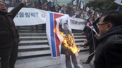 Protesters set a portrait of North Korean leader Kim Jong Un on fire Monday.