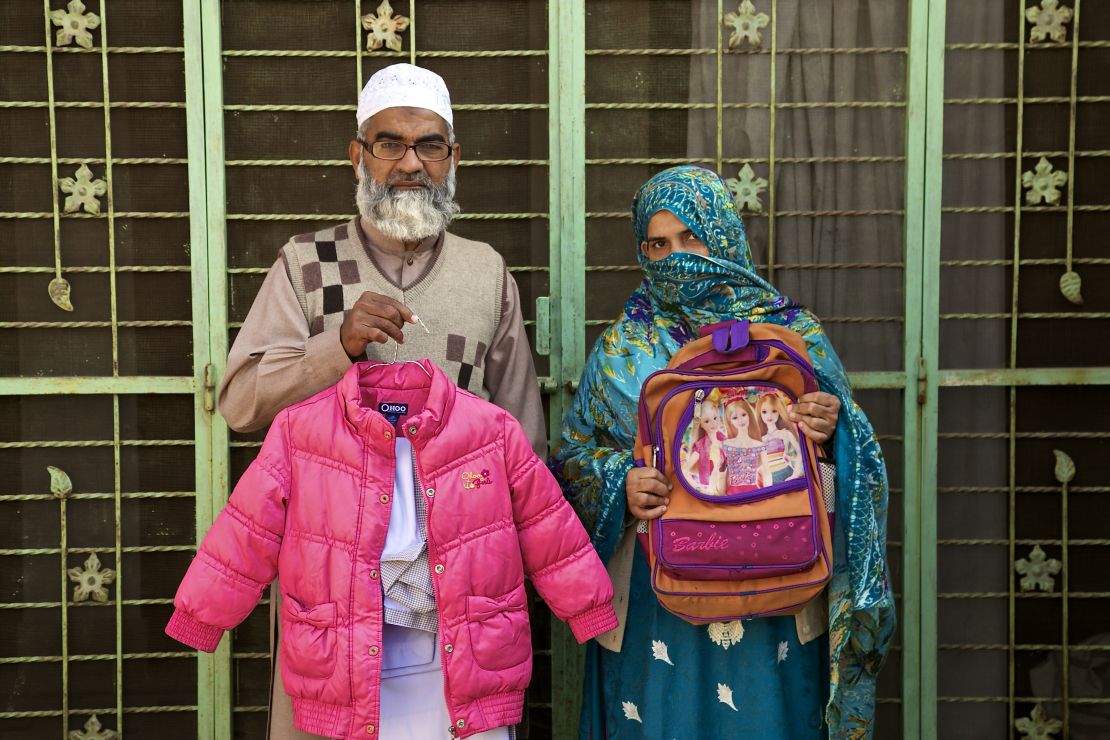 Muhammad Amin Ansari and Nusrat Amin -- the parents of Zainab Ansari -- hold up her school uniform, jacket and schoolbag.