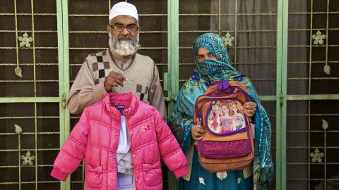 Muhammad Amin Ansari and Nusrat Amin -- the parents of Zainab Ansari -- hold up her school uniform, jacket and schoolbag.