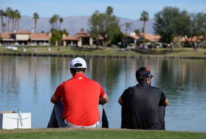 <strong>Taking a break: </strong>Spain's Jon Rahm (left) and Adam Hadwin of Canada wait on the sixth tee during the final round of the CareerBuilder Challenge. Rahm went on to win a four-hole playoff against Andrew Landry for his second PGA Tour title. He also rose to world No. 2