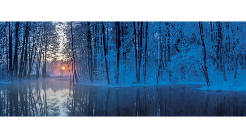 <strong>"At the Water's Edge" category -- Jaak Sarv (Estonia)</strong>: Sarv's image of Prandi Springs, Järva County, Estonia aims to capture "the magic" of an Estonian winter. "As the morning sun peeked out from behind the frost-covered trees it was like being in a fairy tale, with the warm orange light starting to penetrate the desolate blue landscape," he says. "To make the most of the scene I created a stitched panorama, reflecting the cinematic drama of the location."