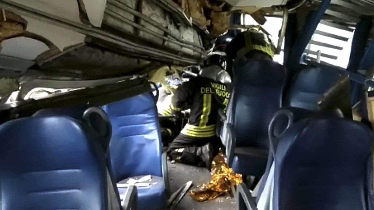 Rescuers inside one of the train carriages try to help a passenger Thursday. 