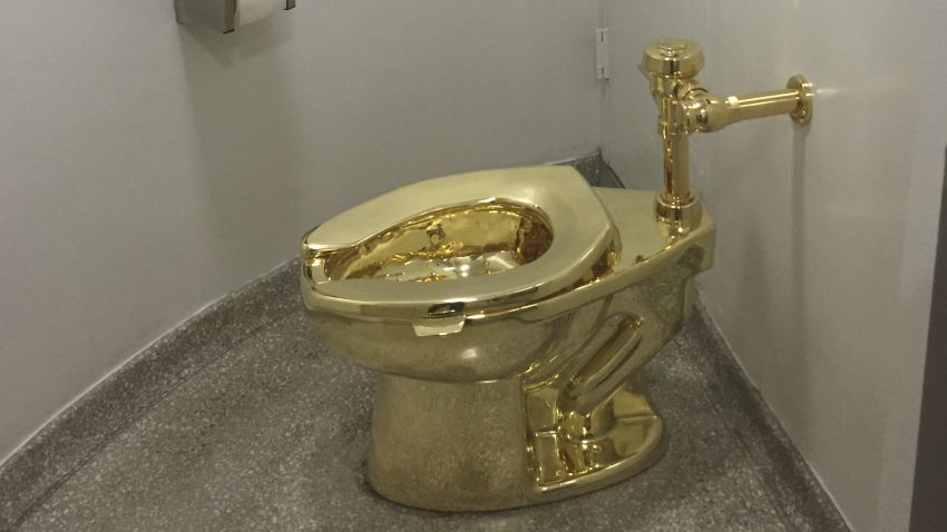A fully functioning solid gold toilet, made by Italian artist Maurizio Cattelan, is going into public use at the Guggenheim Museum in New York on September 15, 2016. 
A guard will be stationed outside the bathroom to protect the work, entitled 'America', which recalls Marcel Duchamp's famous work, 'Fountain'. / AFP / William EDWARDS        