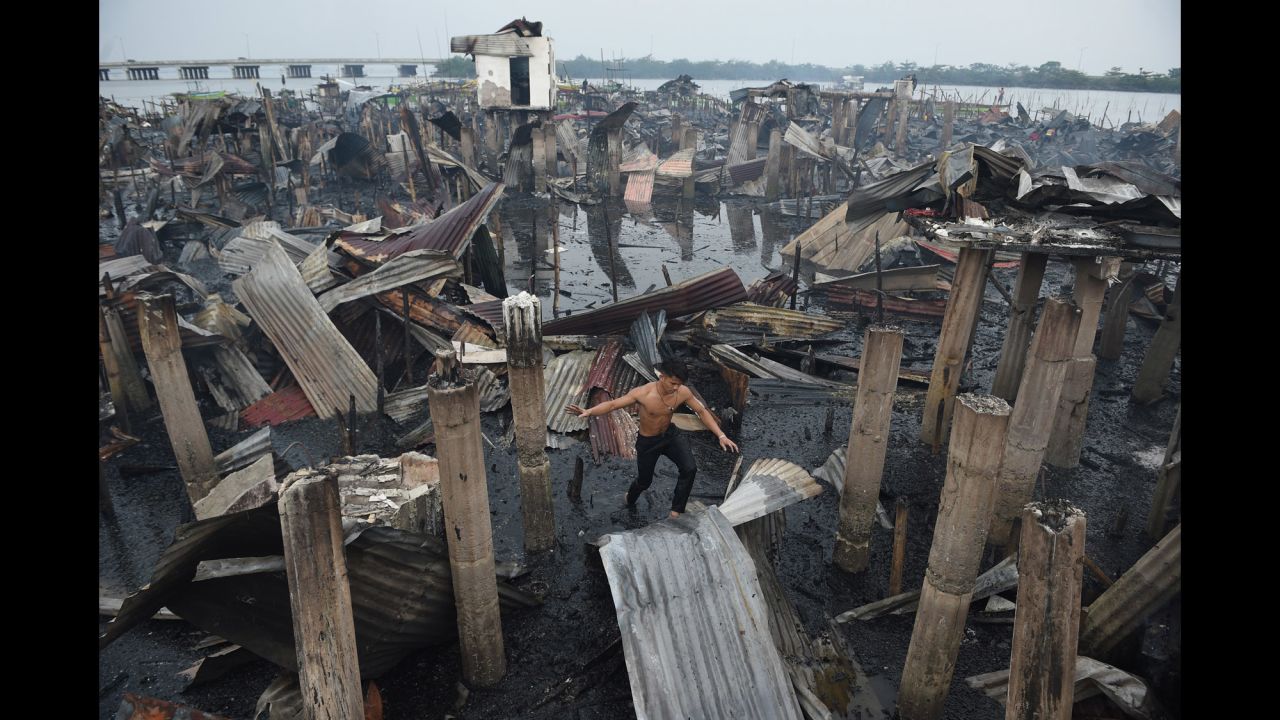 A resident walks on a galvanized roof sheet and destroyed homes after a fire at an informal settlers' area in Cavite province, Philippines, on Wednesday, January 24. "About 400 families lost their homes," <a href="http://newsinfo.inquirer.net/963218/400-families-in-cavite-lose-homes-to-fire" target="_blank" target="_blank">according to the Philippine Daily Inquirer</a>.