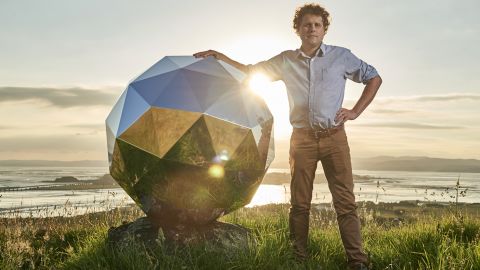 Peter Beck, creater of The Humanity Star, poses next to the satellite.