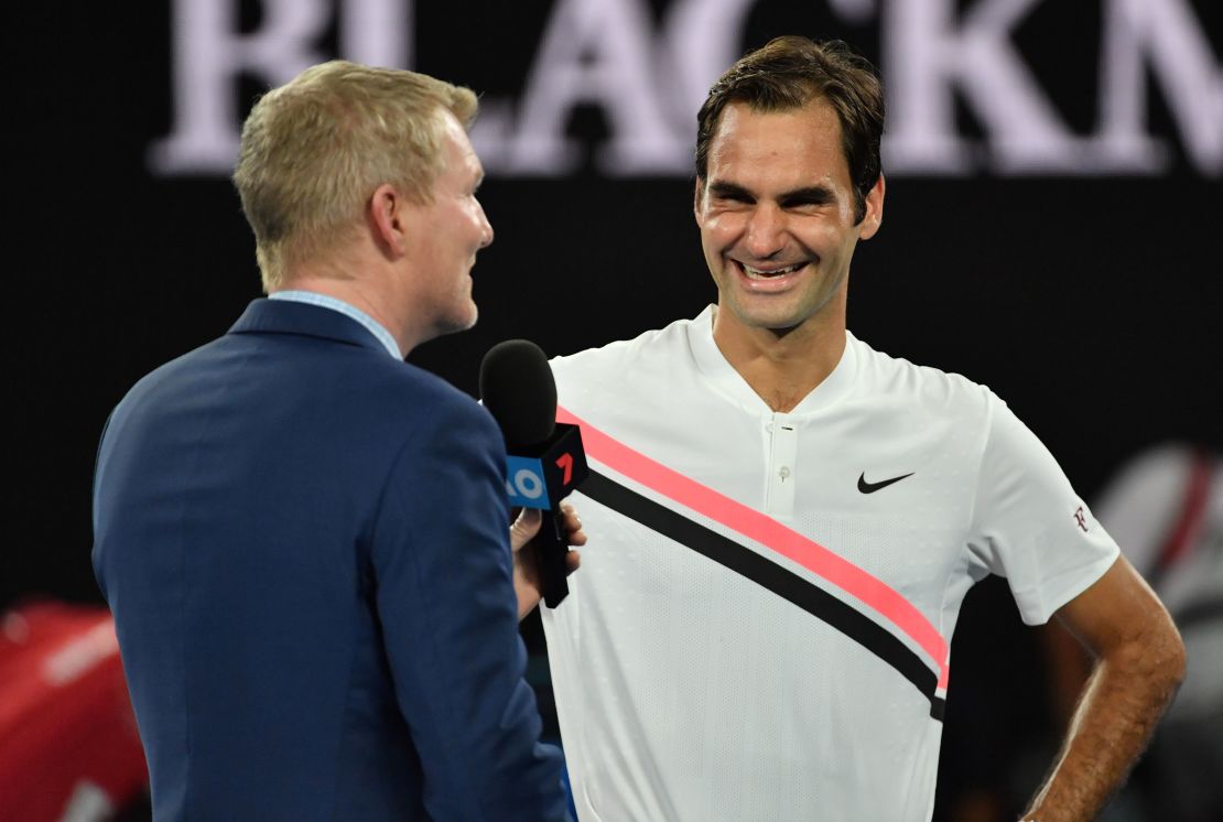 Roger Federer chats to Jim Courier. 