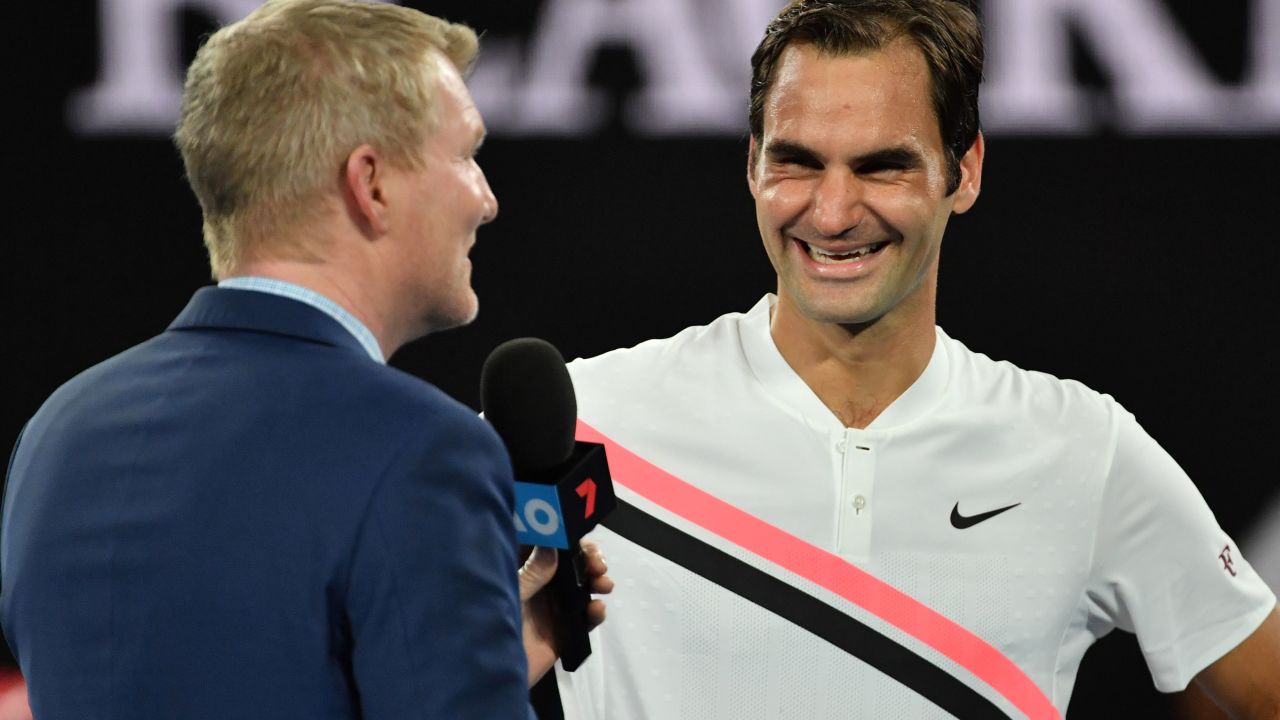 Roger Federer chats to Jim Courier. 