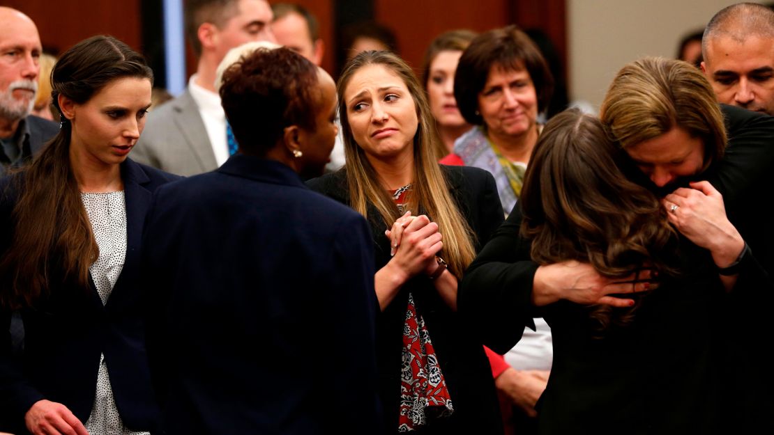 Rachael Denhollander and Kyle Stephens, two survivors of Larry Nassar's abuse, and others embrace at his sentencing. 