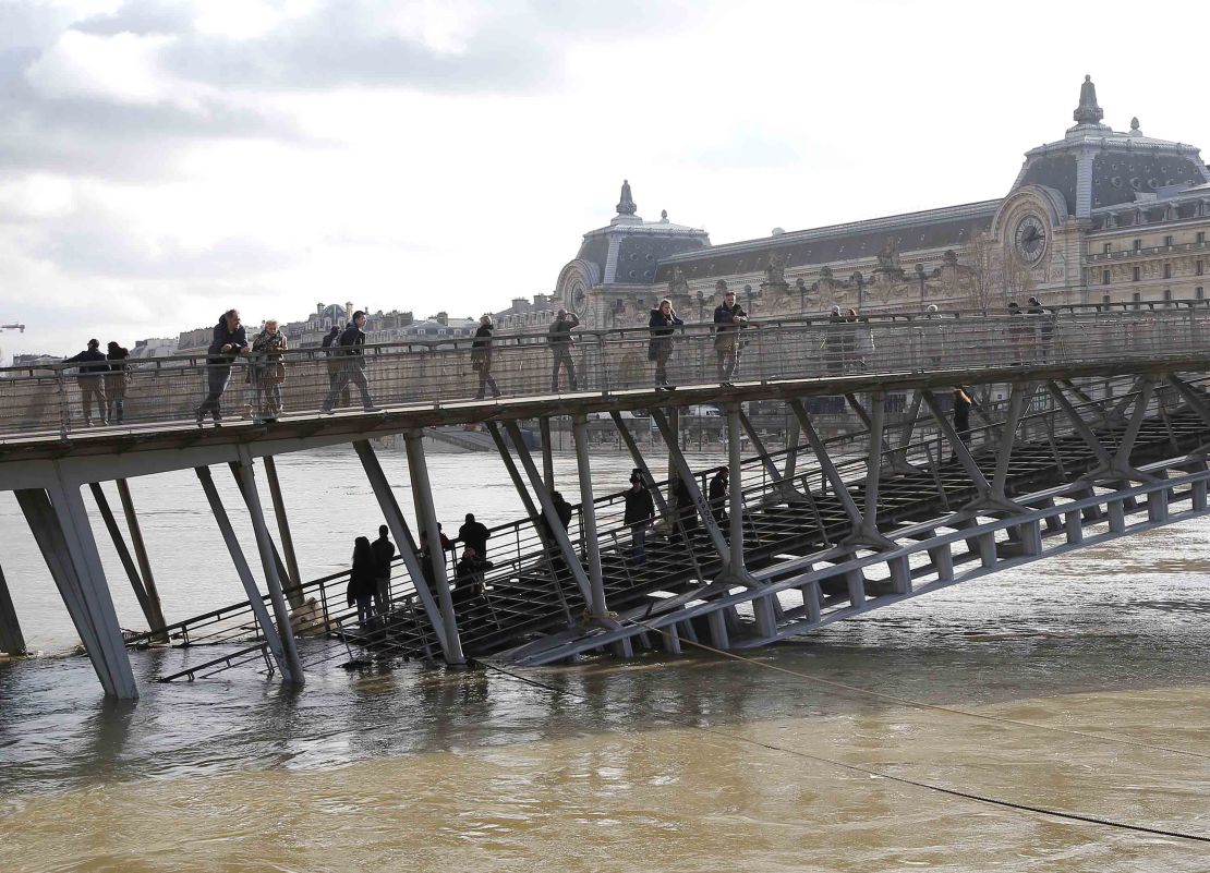People examine the Seine river from the Leopold-Sedar-Senghor bridge in Paris on Friday. 