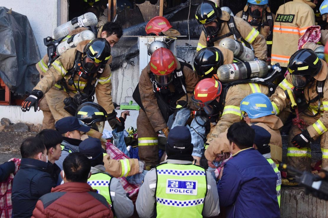 Rescue workers remove bodies from a hospital fire on Friday, January 26, in Miryang, South Korea.