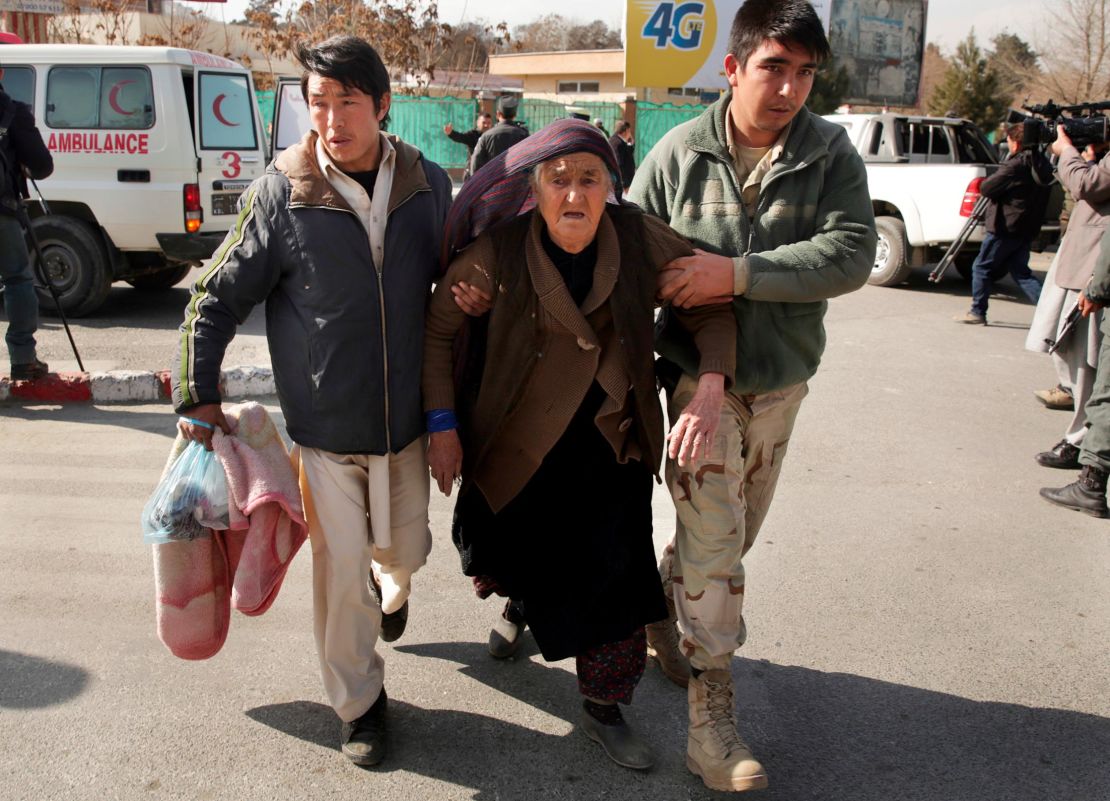 A wounded woman is assisted at the site of the attack Saturday in Kabul.