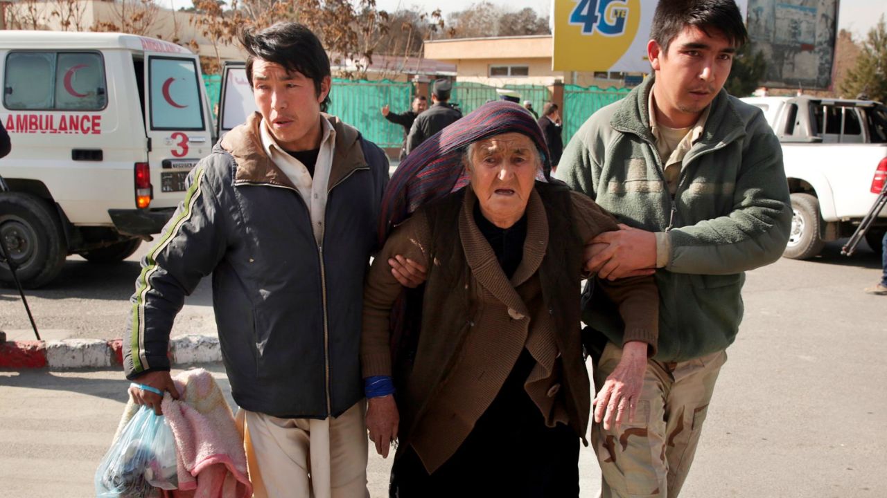 A wounded woman is assisted at the site of the attack Saturday in Kabul.