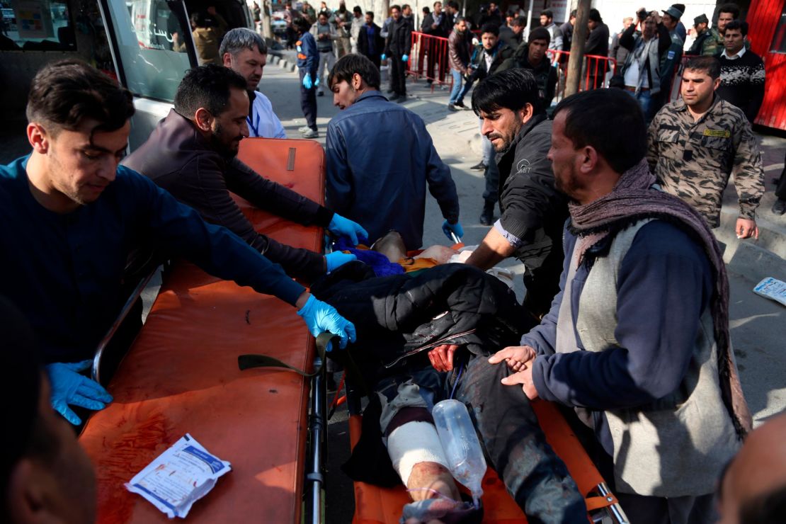 An injured man is moved to a stretcher outside a Kabul hospital following Saturday's attack.