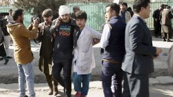 A wounded man is assisted at the site of an explosion in downtown Kabul, Afghanistan, Saturday, Jan. 27, 2018. The Interior Ministry says a suicide car bomb attack in Kabul has left dozens wounded. (AP Photo/Massoud Hossaini)