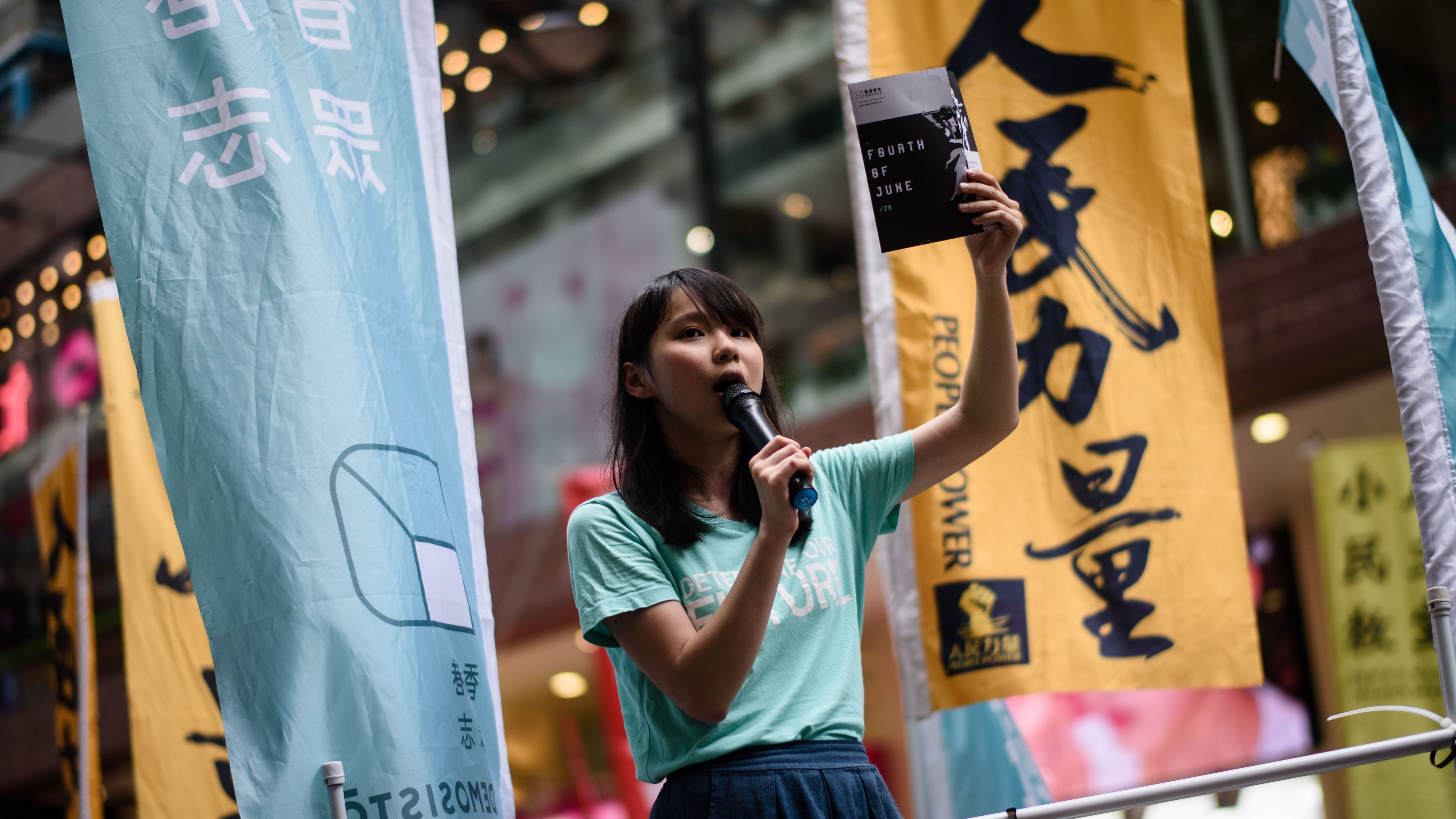 Pro-democracy Demosisto party member Agnes Chow speaks to passing pedestrians in Hong Kong on June 4, 2017.