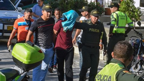 Police escort a suspect arrested in Saturday's blast in Barranquilla.