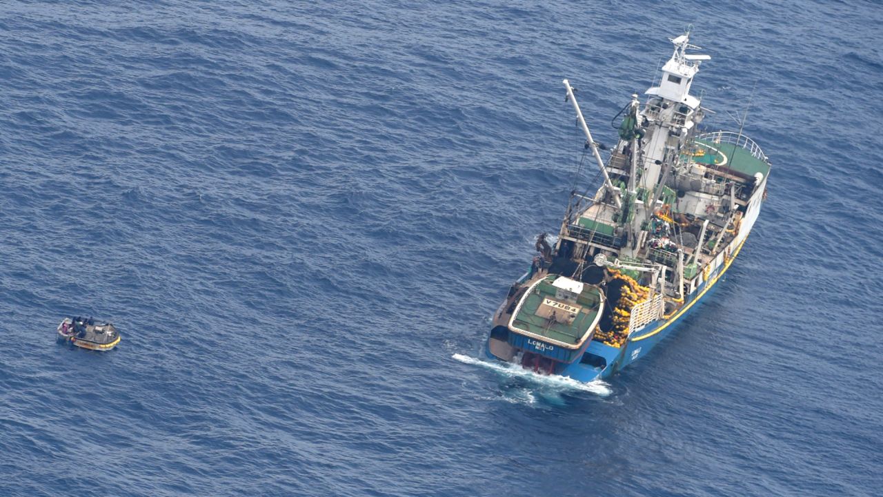 This photo released by the New Zealand defense force shows a wooden dinghy, left, carrying seven survivors from a missing ferry and a fishing boat in the Pacific Ocean on Sunday.