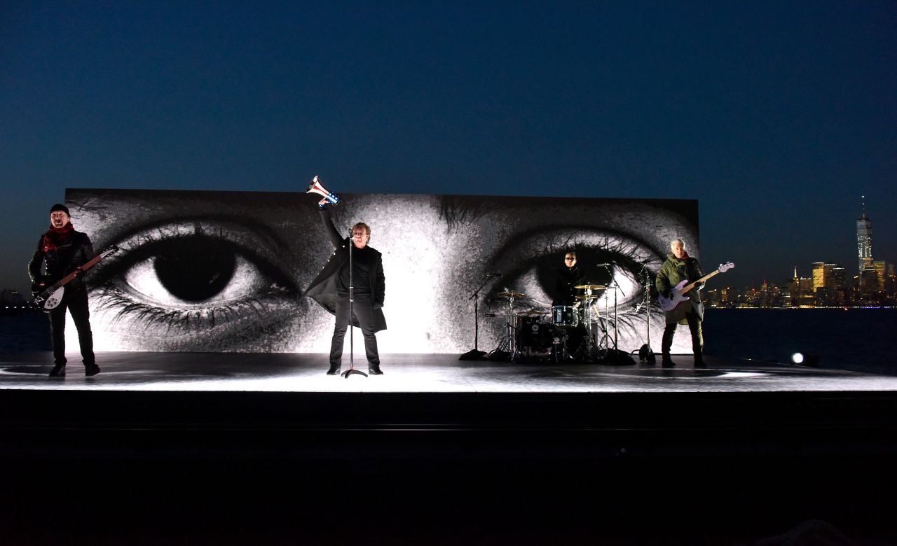 U2 performs "Get Out of Your Own Way" on a barge near the Statue of Liberty.