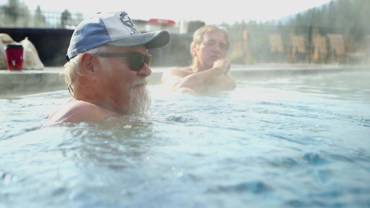 Two friends soak in Olympic-size pool fed by hot springs in Idaho City, Idaho. 