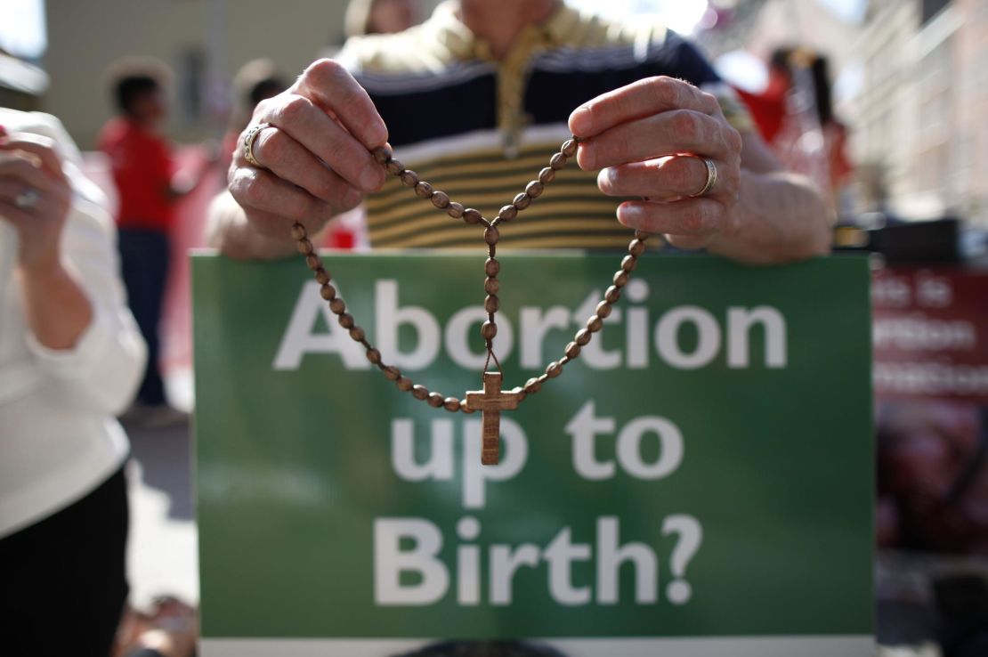 A protester holds rosary beads and an anti-abortion placard in Dublin, Ireland, in July 2013. 