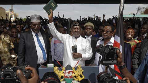 Opposition leader Raila Odinga holds a Bible aloft after swearing an oath during a mock inauguration ceremony at Uhuru Park in downtown Nairobi on Tuesday.