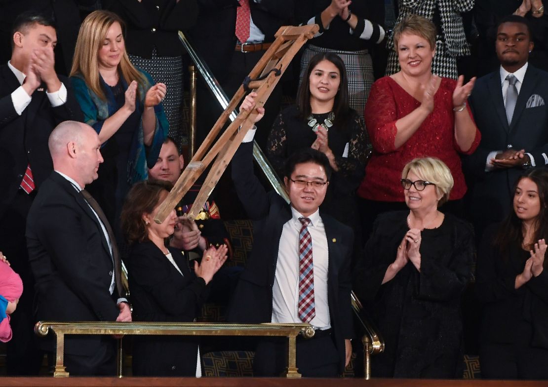 North Korean defector Ji Seong-ho raises his crutches as US President Donald Trump delivers the State of the Union address at the US Capitol in Washington, DC, on January 30, 2018.
 / AFP PHOTO / SAUL LOEB        (Photo credit should read SAUL LOEB/AFP/Getty Images)