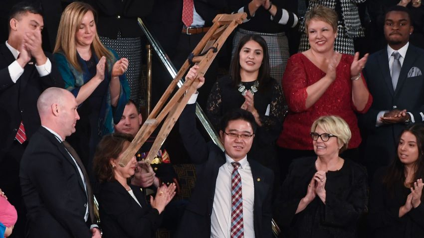 North Korean defector Ji Seong-ho raises his crutches as US President Donald Trump delivers the State of the Union address at the US Capitol in Washington, DC, on January 30, 2018.
 / AFP PHOTO / SAUL LOEB        (Photo credit should read SAUL LOEB/AFP/Getty Images)