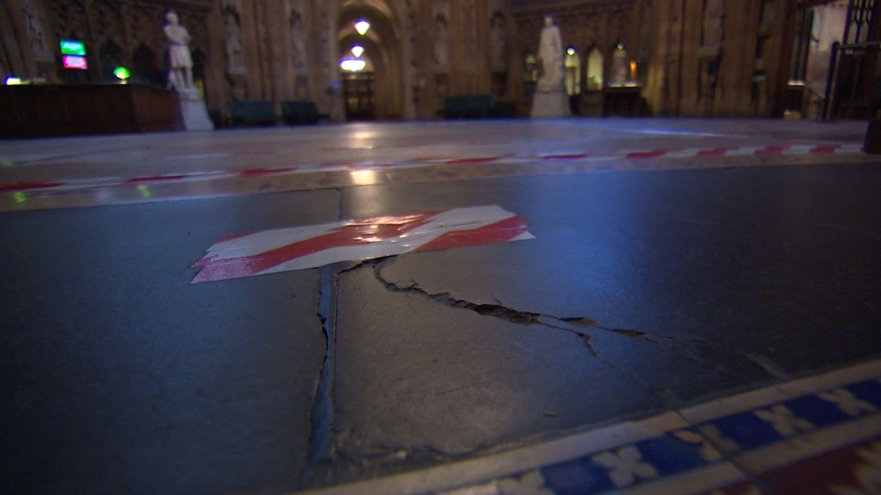 A cracked stone floor is seen within the Palace of Westminster.