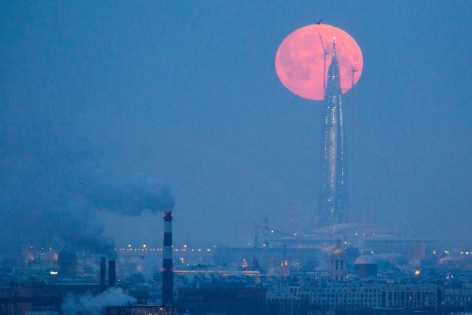 The supermoon passes over the tower of the Lakhta Center in St. Petersburg, Russia.