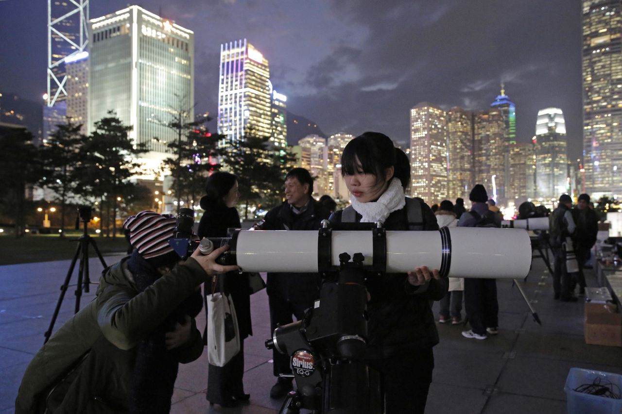 People use telescopes to view the moon at Victoria Harbor in Hong Kong.