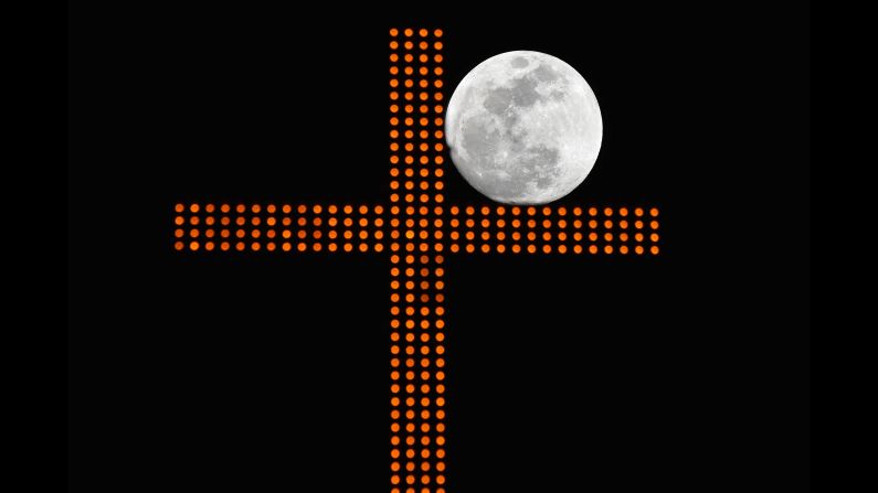 The supermoon is framed by a cross in Beirut, Lebanon.