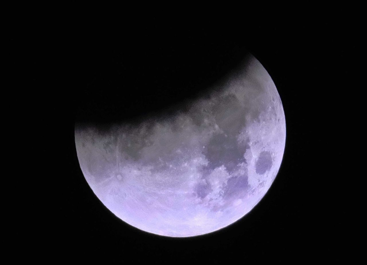 The shadow of Earth passes across the supermoon during a total lunar eclipse, as seen from Los Angeles.