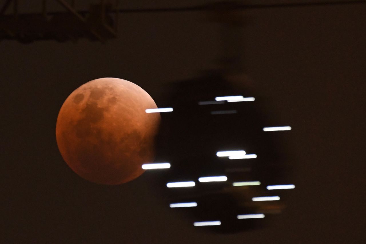 A cable car gondola moves past the moon in Singapore.