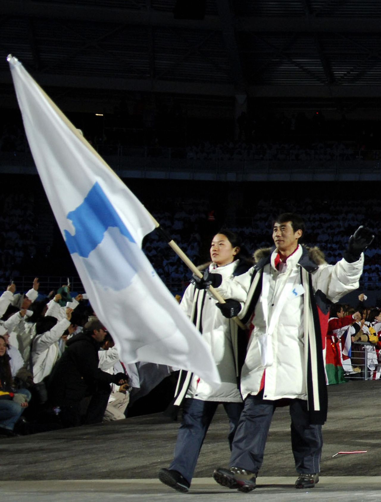 South Korean speed skater Lee Bora (left) and North Korean figure skater Han Jong-In lead their delegation as they arrive for the opening ceremony of the 2006 Winter Olympics at the Olympic stadium in Turin, Italy.