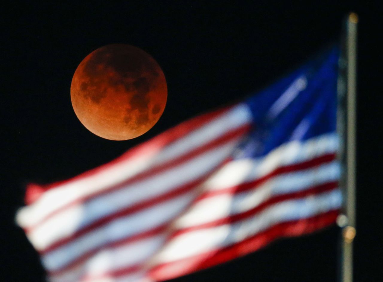 The supermoon is seen behind the US flag at Santa Monica Beach in Santa Monica, California.