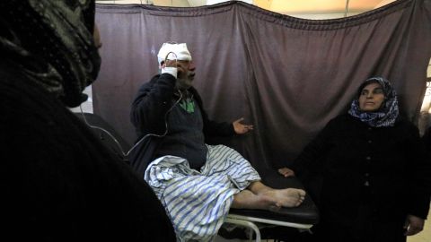 A wounded Kurdish man talks on the phone at the hospital.