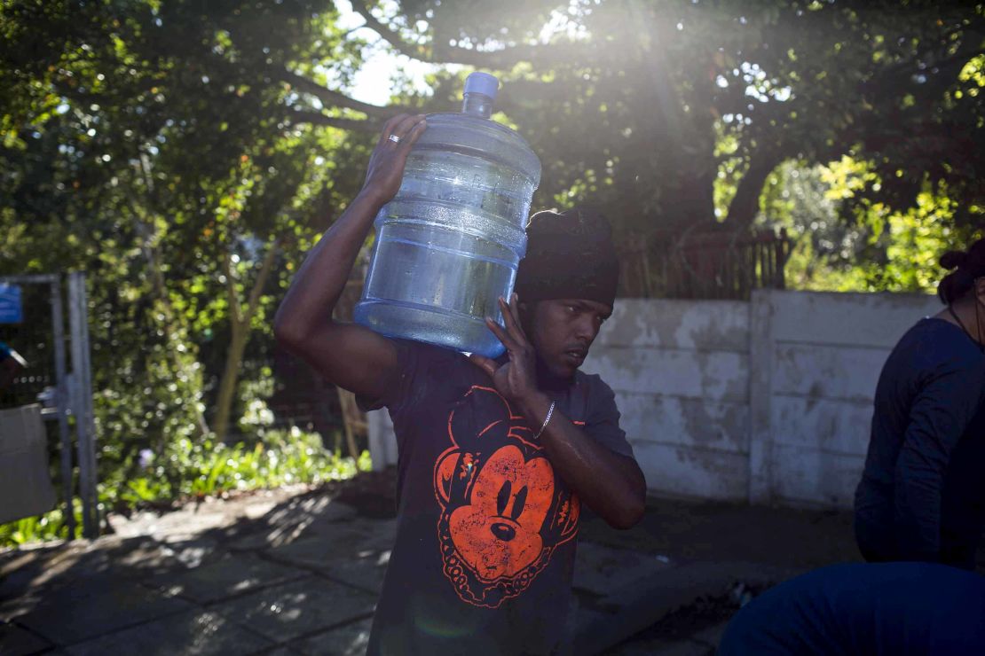 A man carries water at a source for natural spring water in Cape Town on Thursday.