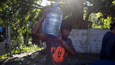 A man carries water at a source for natural spring water in Cape Town on Thursday.