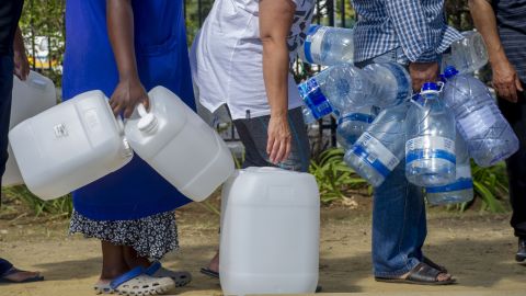 People queue to collect water from a natural spring outlet in the South African Breweries in Cape Town.