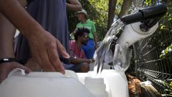 Residents fill containers with water at a source for natural spring water in Cape Town, South Africa, Thursday, Feb. 1, 2018. South Africa's drought-hit city of Cape Town plans to introduce new water restrictions on Thursday in an attempt to avoid what it calls "Day Zero," the day in mid-April when it might have to turn off most taps. Residents will be asked to use no more than 50 liters of water daily, down from the current limit of 87 liters. (AP Photo/Halden Krog)
