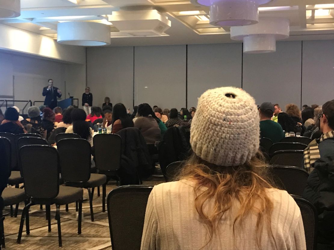 Nassar survivor Kat Ebert, in white, listens as MSU trustee Mosallam speaks at a Thursday town hall on campus. 